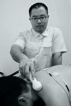 photo of chiropractor performing ultrasound treatment of neck pain